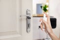 Woman sanitizing door handle with antiseptic spray. Be safety during coronavirus outbreak