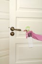 Woman sanitizing door handle with antiseptic spray. Be safety during coronavirus outbreak