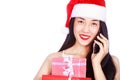 Woman in Santa Claus clothes calling on mobile phone with gift b Royalty Free Stock Photo