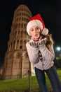 Woman in Santa hat blowing air kiss near Leaning Tower of Pisa Royalty Free Stock Photo