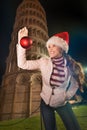 Woman in Santa hat with Christmas ball near Leaning Tower, Pisa Royalty Free Stock Photo
