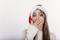 Woman in santa hat covering her mouth by hand Royalty Free Stock Photo