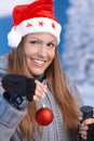 Woman in santa hat holding christmas decoration Royalty Free Stock Photo