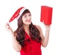 Woman in santa hat holding Christmas gift box isolated on white with copyspace. Happy exited girl unpacking her present Royalty Free Stock Photo