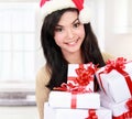 Woman in Santa hat holding Christmas gifts Royalty Free Stock Photo