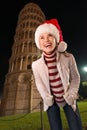 Woman in Santa hat looking up near Leaning Tower of Pisa Royalty Free Stock Photo