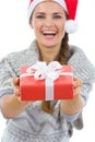 Woman in Santa hat presenting Christmas gift box