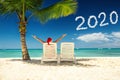 Woman in santa`s hat relaxing on tropical beach. Happy new year 2020