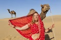 Woman in sari in desert with camels. Royalty Free Stock Photo