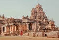 Woman in sari walking past walls of the 7th century Hindu temples, India. Architecture of Pattadakal