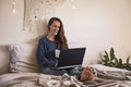 Woman sat in bed using laptop computer Royalty Free Stock Photo