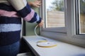 Woman Saving Energy Insulating Home Putting Draught Excluder Tape On Window Royalty Free Stock Photo