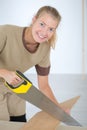 Woman sawing wood smiling portrait