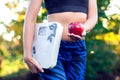 Woman with scale and red apple outdoor. Slimming, diet and healthy lifestyles concept Royalty Free Stock Photo