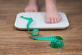 Woman on the scales with a measuring tape, close-up. Diet, healthy lifestyle, weight loss, slim concept. Close-up of the Royalty Free Stock Photo