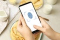 Woman scanning fingerprint on smartphone, closeup. Digital identity