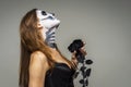 Woman with scary Halloween skeleton makeup holding black rose flower over gray background Royalty Free Stock Photo