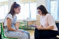 Woman school psychologist talking and helping student, teenage girl