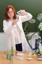 Woman scientist biologist with a bottle of clean water in her hands and test tubes on the table. Chemical research in the Royalty Free Stock Photo