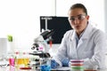 Woman scientist chemist sitting in front of microscope in laboratory