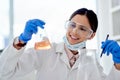 Woman, scientist and happy in lab with chemical reaction in glass for research, study and scientific experiment