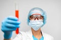 Woman scientist holding laboratory flask with chemical liquid, gray background Royalty Free Stock Photo