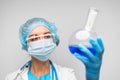 Woman scientist holding laboratory flask with chemical liquid, gray background Royalty Free Stock Photo