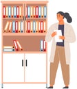 Woman scientist in lab coat working with scientific documents, informative folders in bookcase