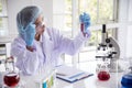Woman scientist in lab look at science microscope medical test and research biology chemistry. Females technician laboratory Royalty Free Stock Photo