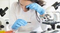 Woman scientist looking through magnifying glass at computer chip near microscope in laboratory Royalty Free Stock Photo