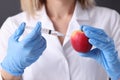 Woman scientist in rubber gloves making injection into apple closeup Royalty Free Stock Photo