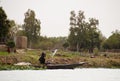 Woman scooping water out of a canoe in Mali Royalty Free Stock Photo