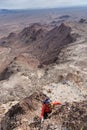 Woman Scrambling Up A Desert Mountain Royalty Free Stock Photo