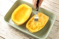 Woman scraping flesh of cooked spaghetti squash Royalty Free Stock Photo