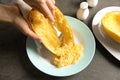 Woman scraping flesh of cooked spaghetti squash with fork on table Royalty Free Stock Photo