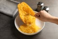 Woman scraping flesh of cooked spaghetti squash with fork at table