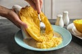 Woman scraping flesh of cooked spaghetti squash with fork on table Royalty Free Stock Photo