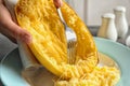 Woman scraping flesh of cooked spaghetti squash with fork on table Royalty Free Stock Photo