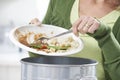 Woman Scraping Food Leftovers Into Garbage Bin Royalty Free Stock Photo