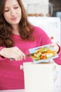 Woman Scraping Vegetable Peelings Into Recycling Bin