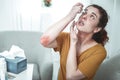 Woman with scratch marks on her elbow using eye drops