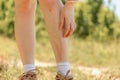 A woman scratches her legs with redness and irritation from insect bites. Close-up of feet. The concept of protection Royalty Free Stock Photo