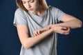 Woman scratching forearm on color background. Allergy symptom Royalty Free Stock Photo