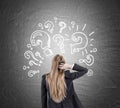 Woman scratching head and question marks on blackboard Royalty Free Stock Photo