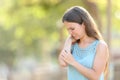 Woman scratching because her arm itches in a park Royalty Free Stock Photo