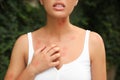 Woman scratching insect bites in park, closeup