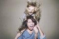 Woman is screaming and arguing with a child on his shoulders clinging to her hair