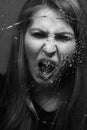 Woman screaming through broken glass. Black and white Royalty Free Stock Photo