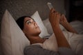 Woman, scroll and phone for social media, bed and relaxation under blankets in pajamas to sleep. Female person, browse Royalty Free Stock Photo