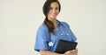 Woman in scrubs holds black portfolio and smiles